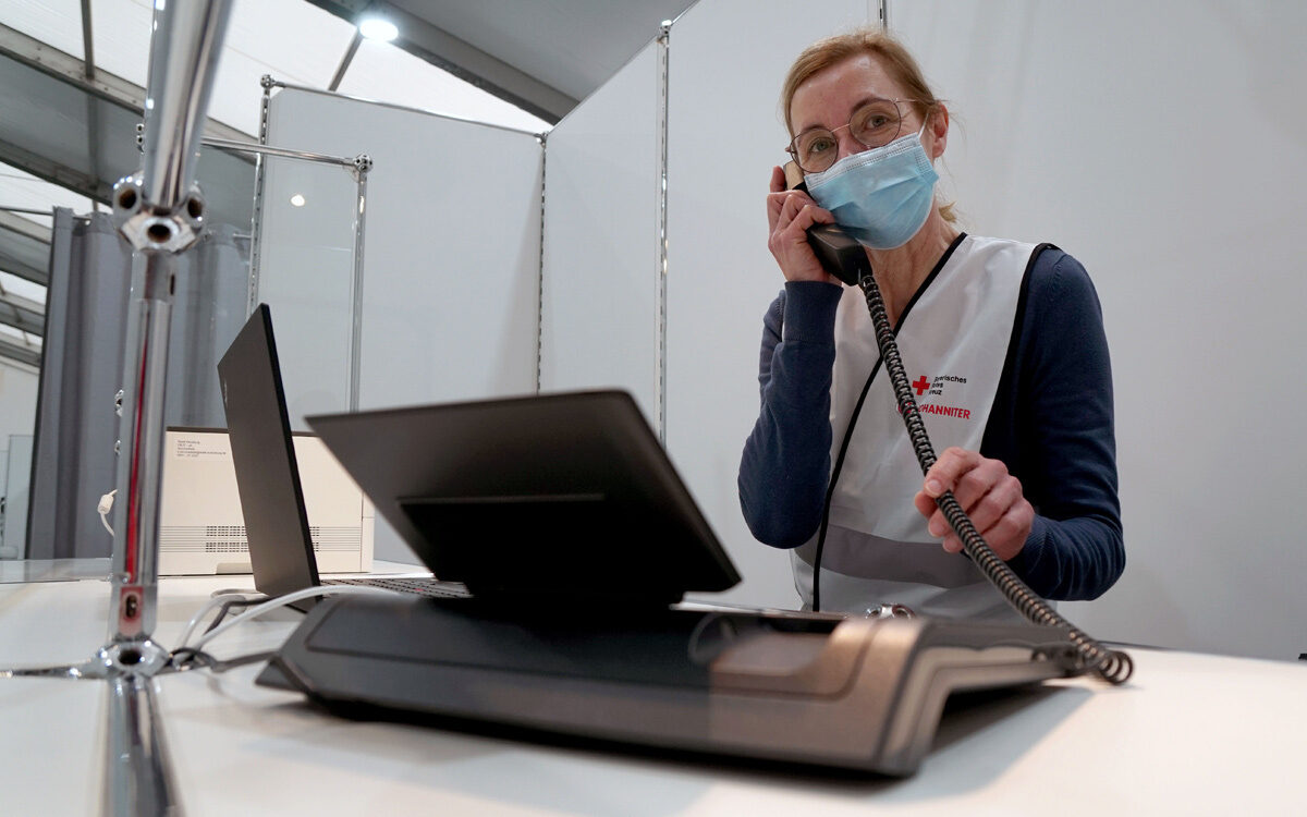 Impfzentrum Würzburg eine Mitarbeiterin sitzt am Telefon Impfzentrum Würzburg eine Mitarbeiterin sitzt am Telefon